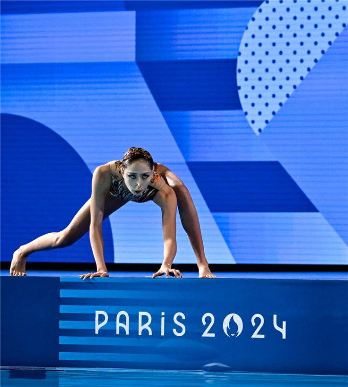 Femme sautant d'un plongeoir dans une piscine olympique